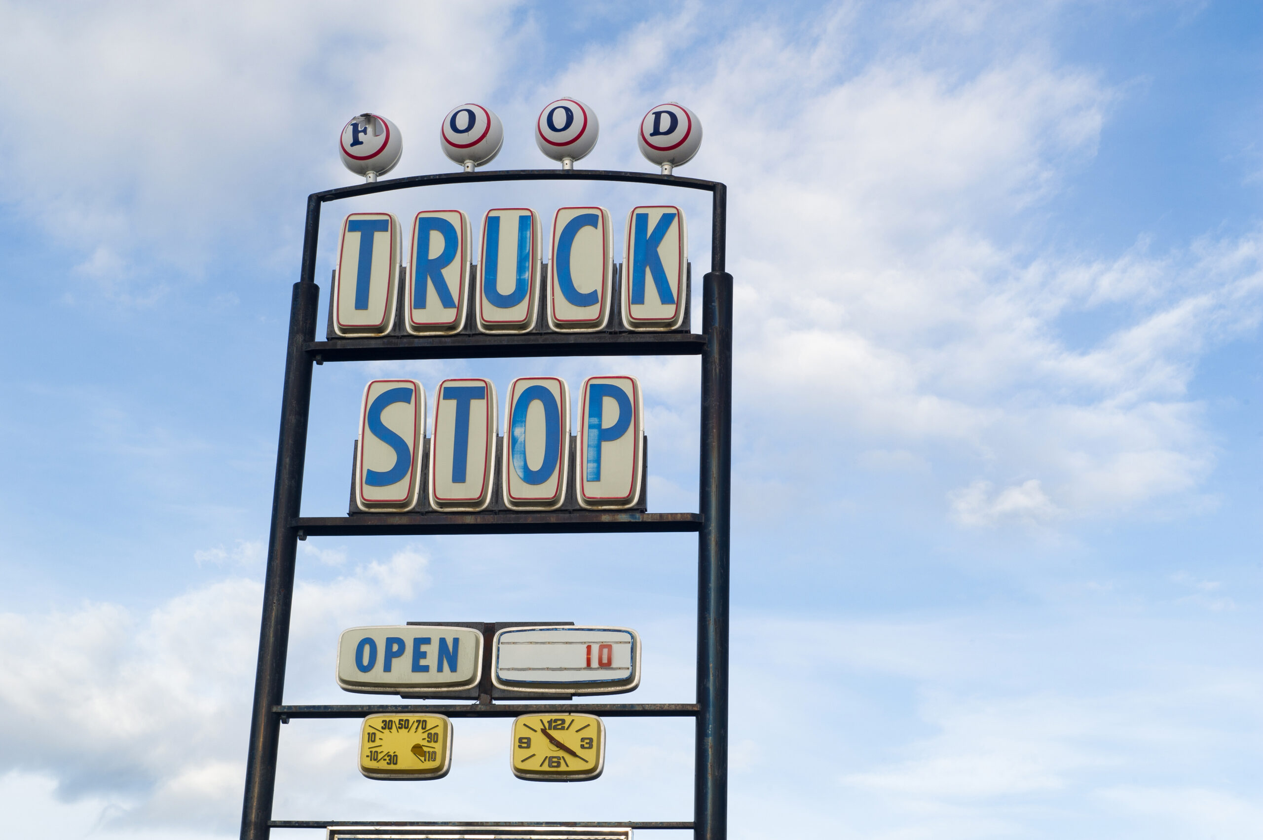 Vintage truck stop sign against a blue sky, representing travel-related bed bug risks in Centralia, Washington